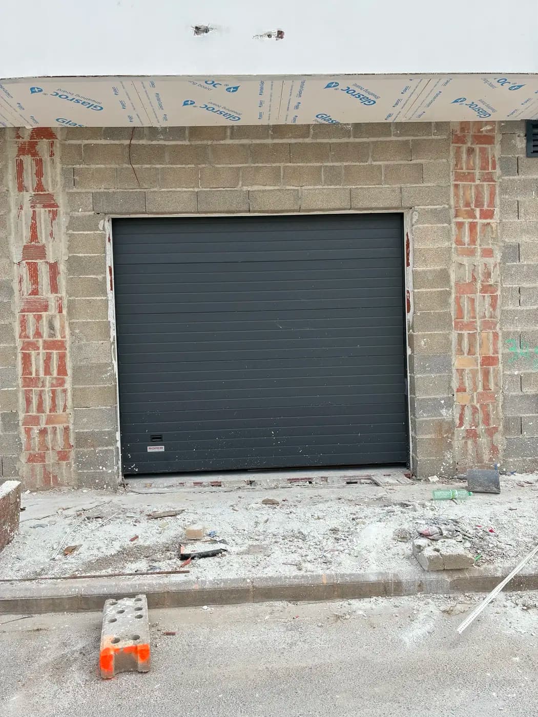 Puerta seccional antracita instalada en fachada