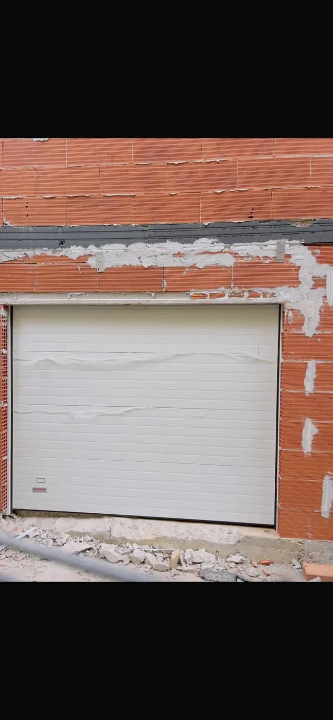 Puerta seccional blanca instalada durante obra