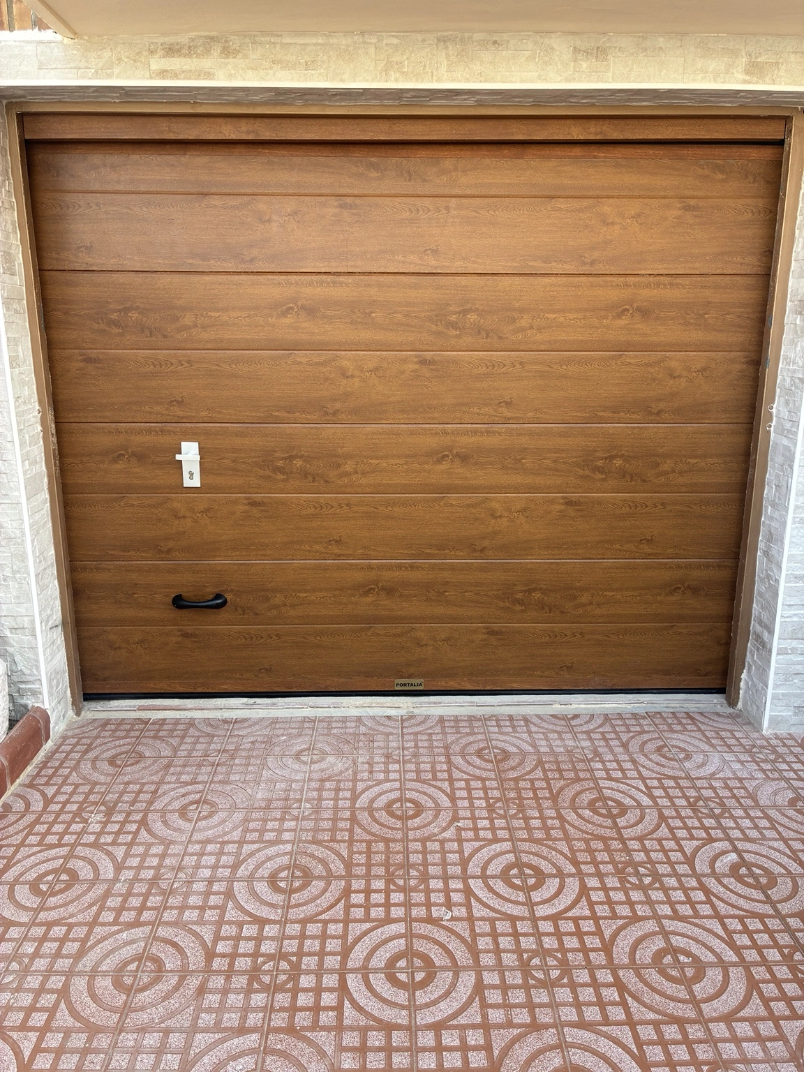 Después: nueva puerta seccional con acabado imitación madera en Beniparrell. Beniparrell
