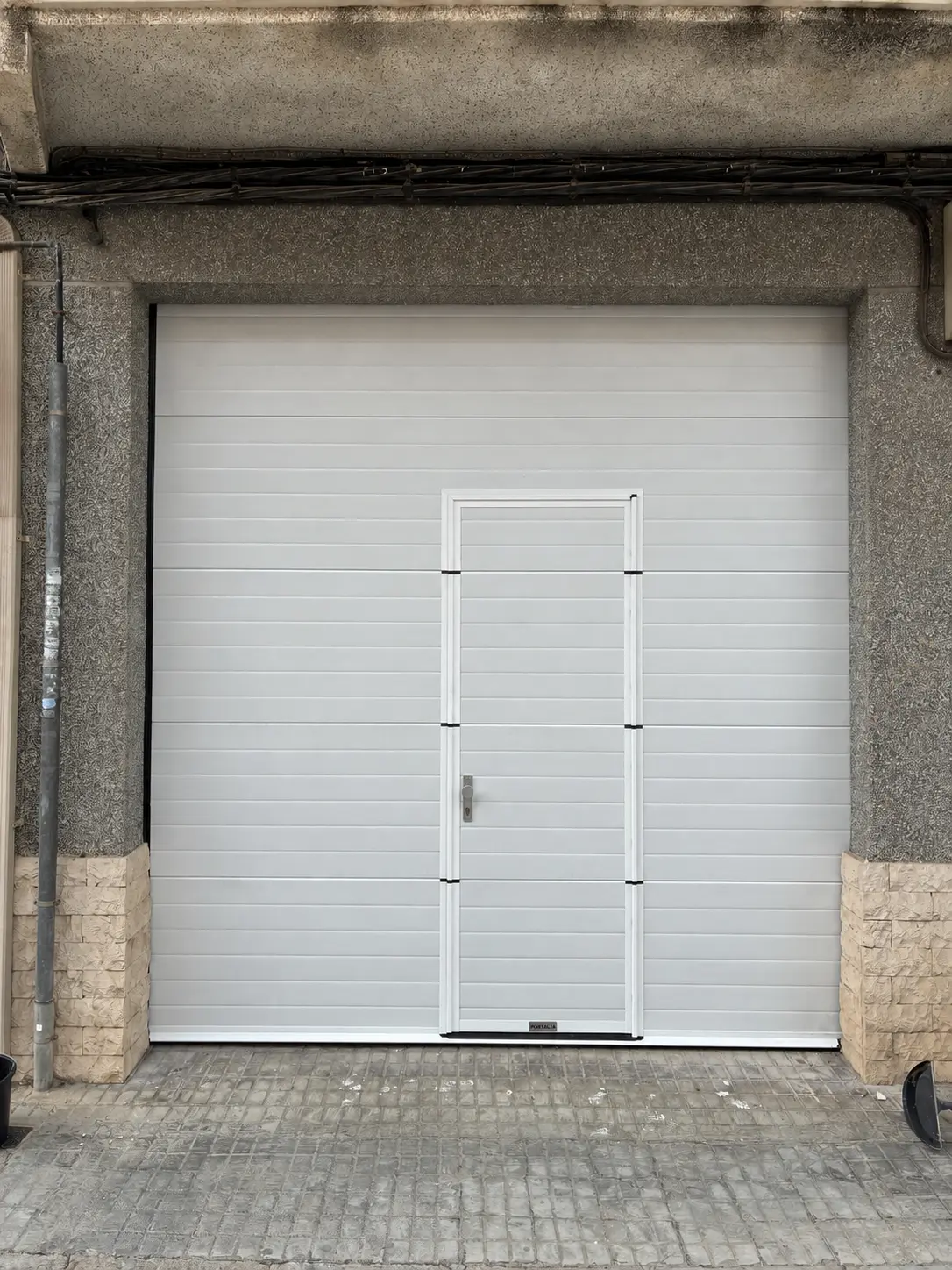 Resultado: puerta seccional blanca con peatonal integrada en Beniparrell. Beniparrell