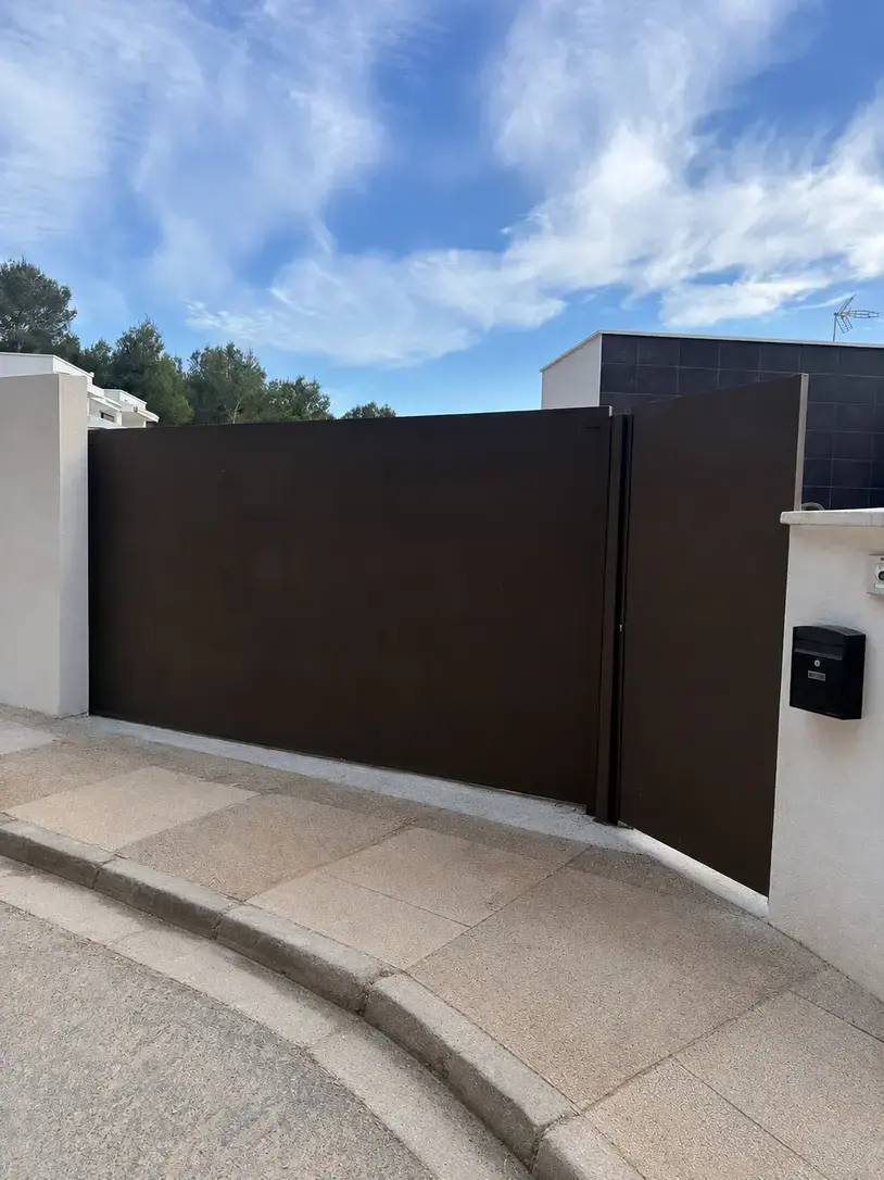 Puerta corredera fabricada a medida con peatonal integrada en El Bosque, Chiva. Urbanización El Bosque · Chiva
