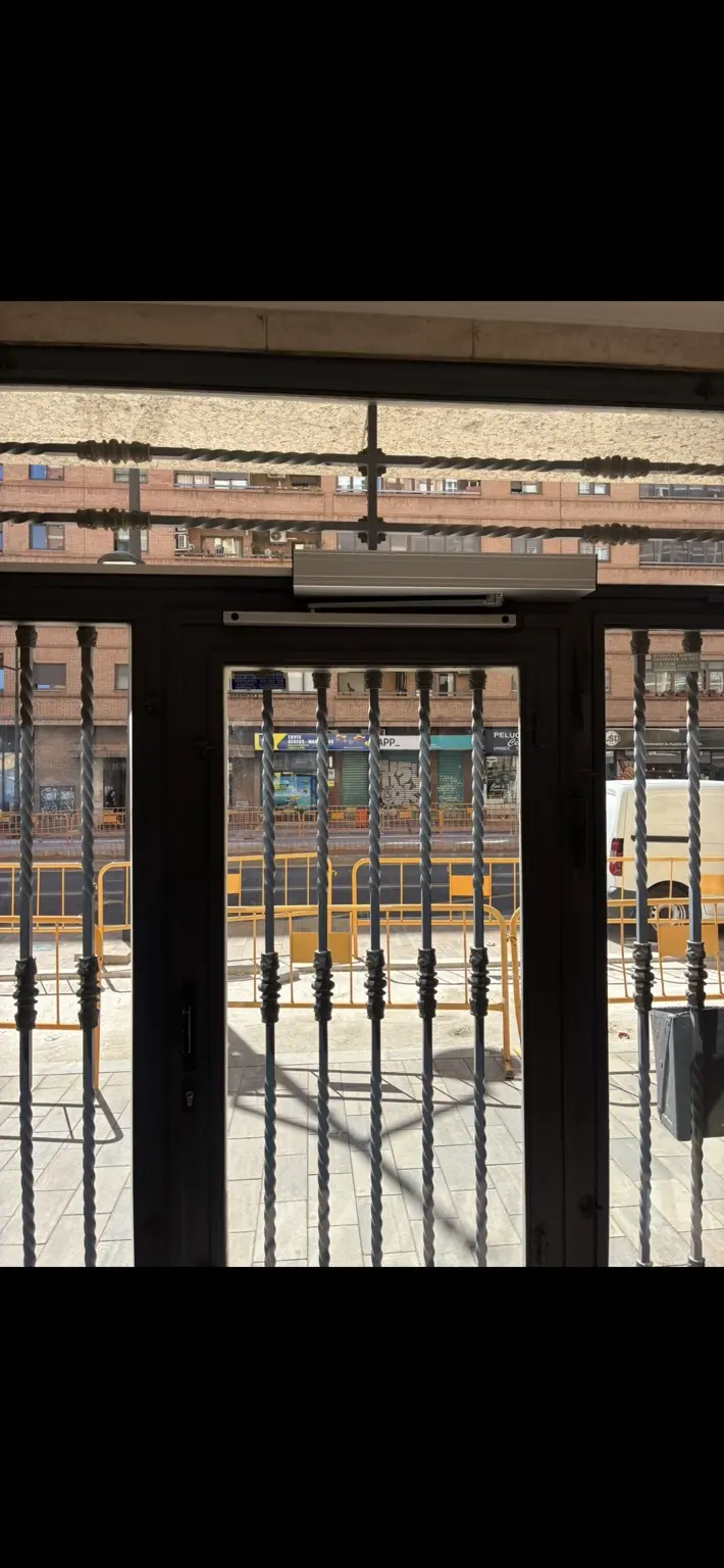 Operador automático instalado sobre la puerta peatonal del patio comunitario. Valencia